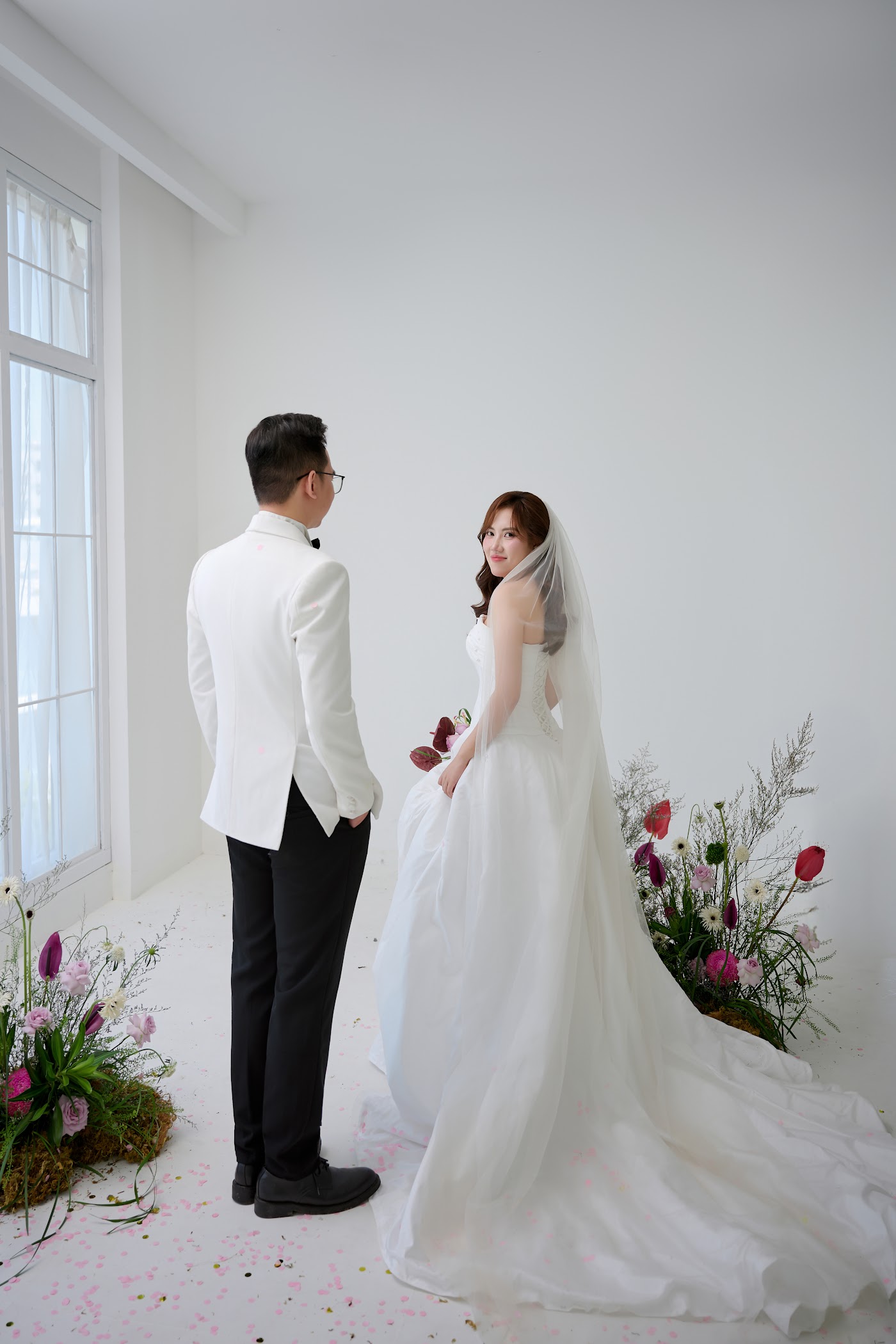 Ảnh studio: cô dâu chú rể nhìn nhau trong ánh sáng cửa sổ